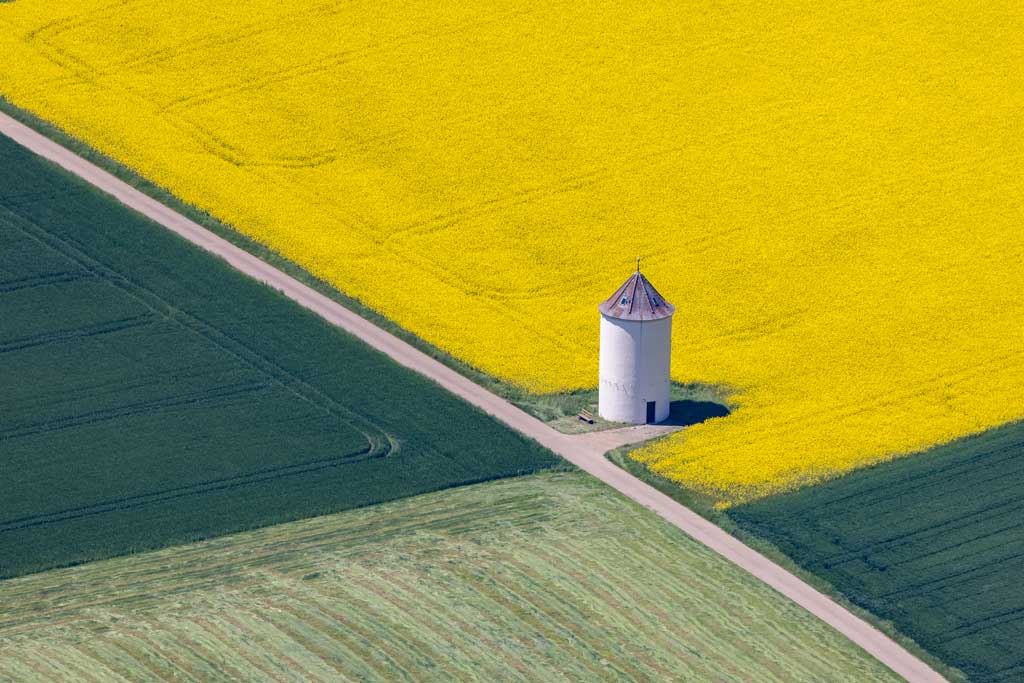 Water tower by the blooming rapeseed field 