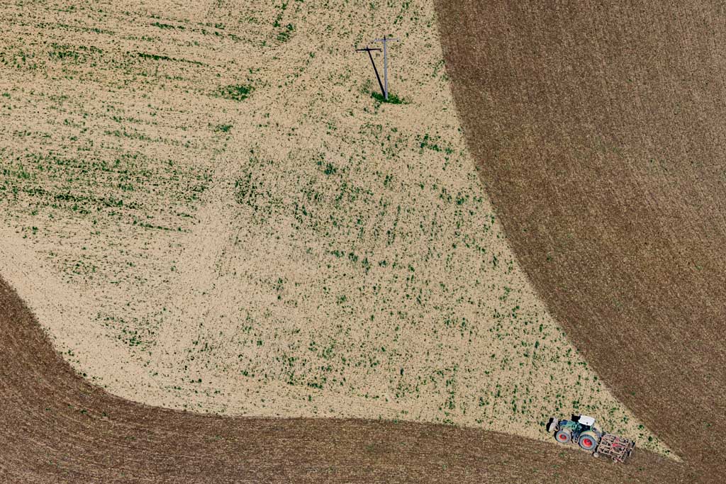 Traktor mit Egge hinterlässt Spuren auf dem Feld