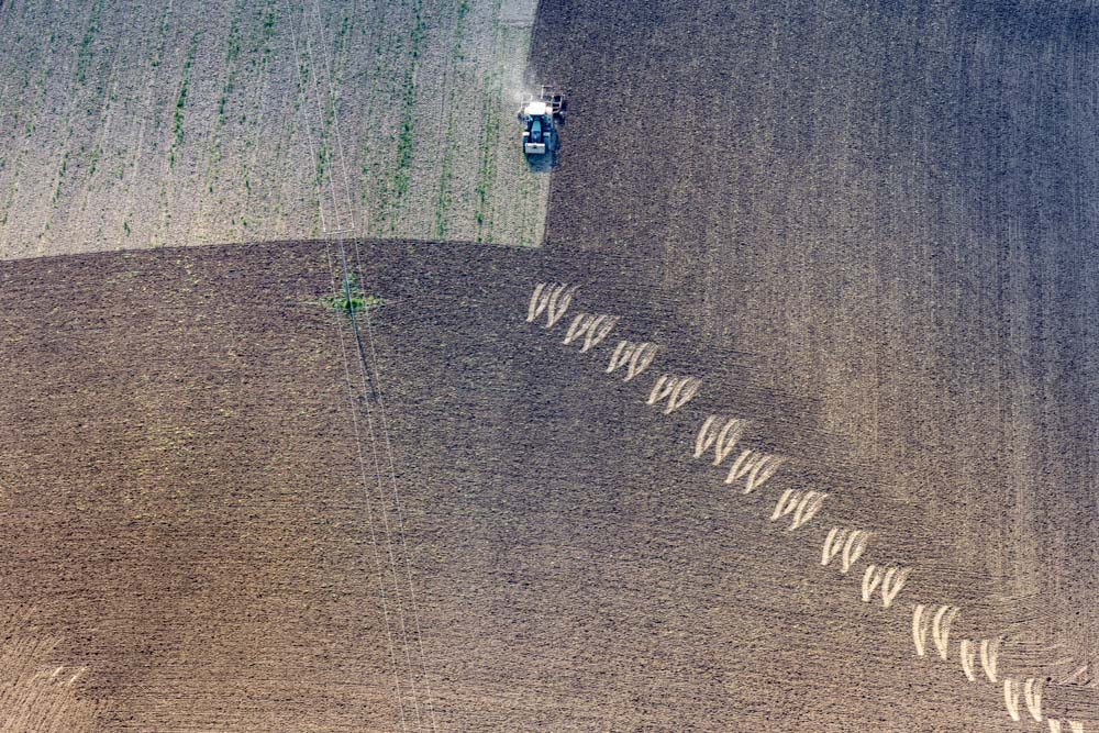 Traktor mit Egge hinterlässt Spuren auf dem Feld hinterlässt