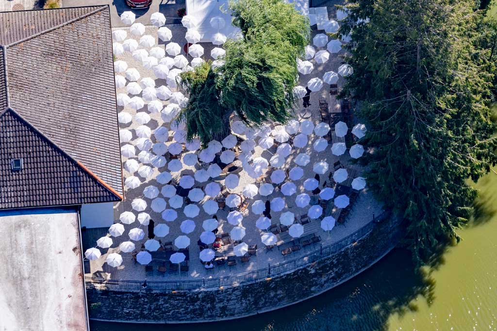 Biergarten unter weißen Sonnenschirmen