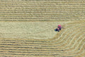 Red tractor turning hay 