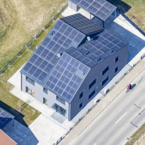 Roter Radler vor modernem Doppelhaus - Klaus Leidorf